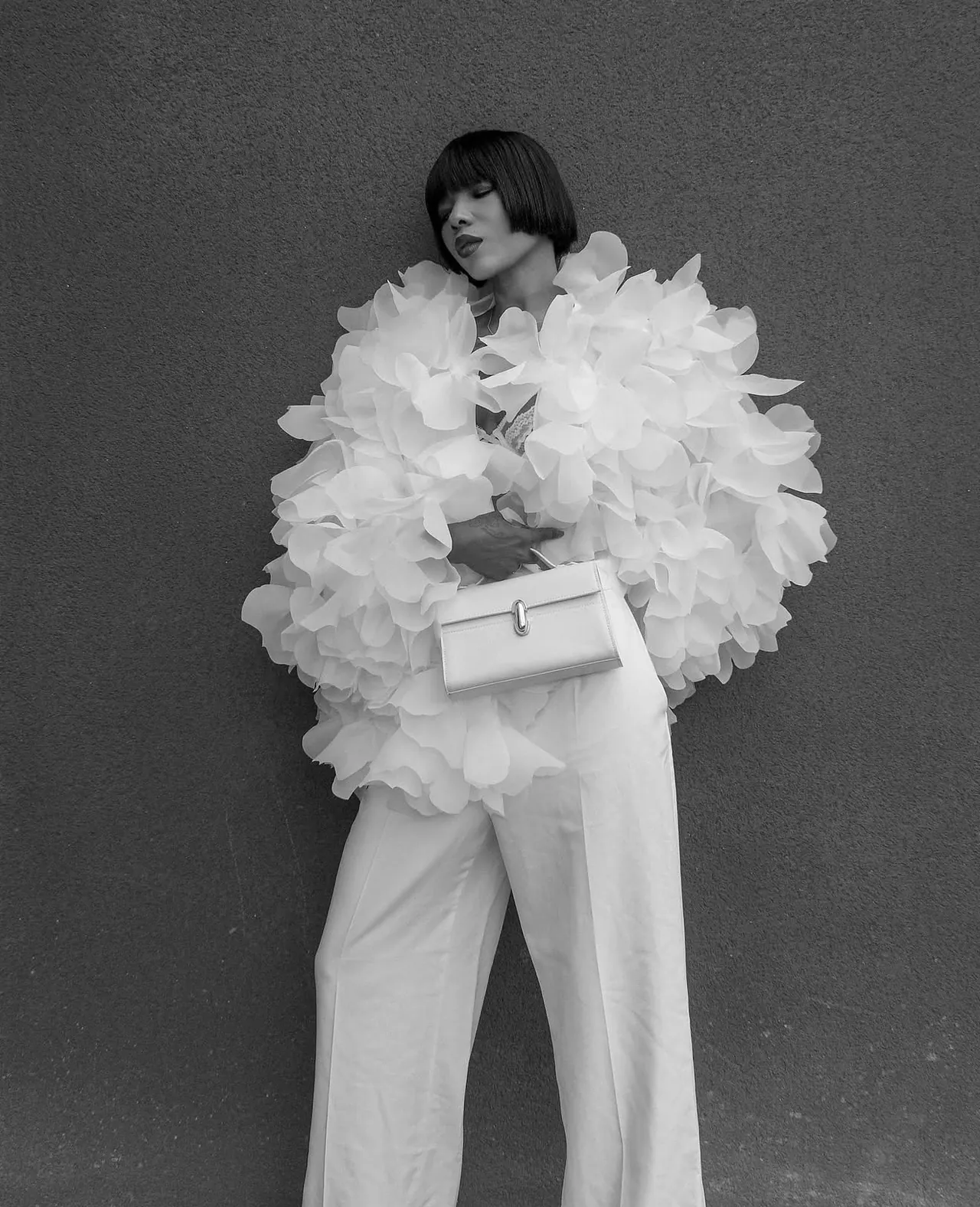 Nafybellaa dans une silhouette blanche sculpturale avec sac couture